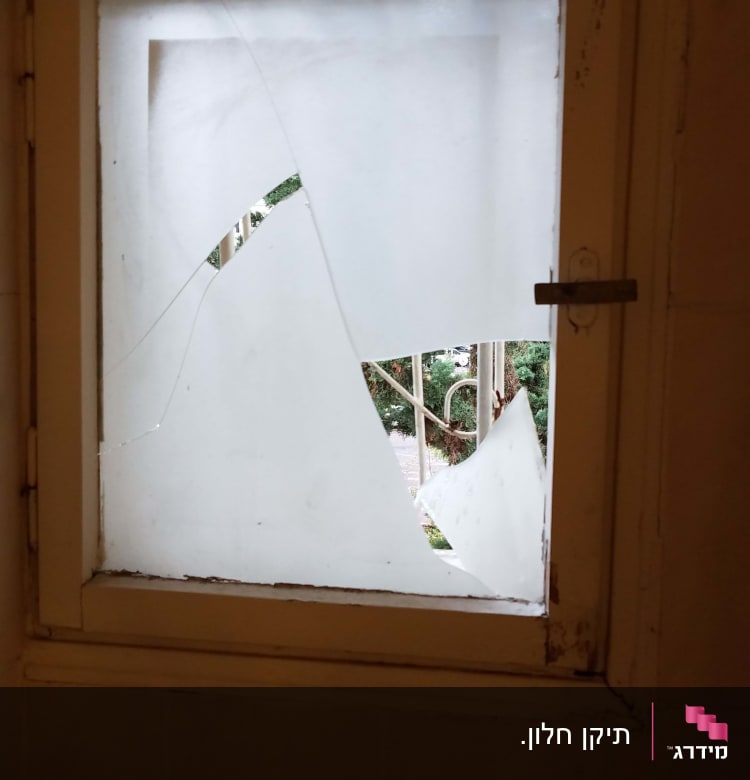 חלון עם זכוכית שבורה וחלקים חסרים